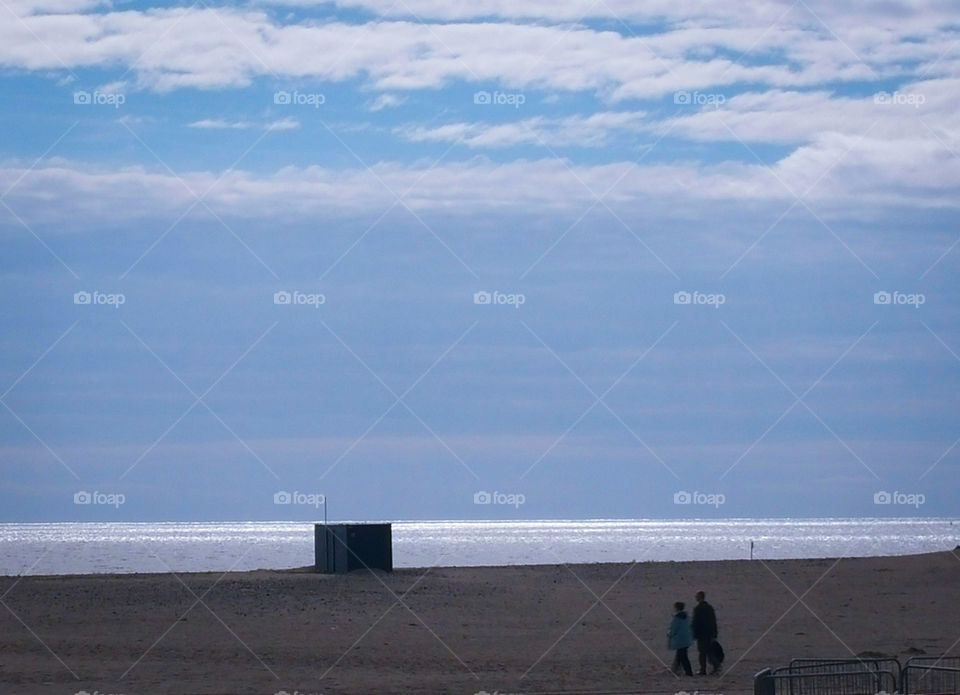 Two people walking on the beach