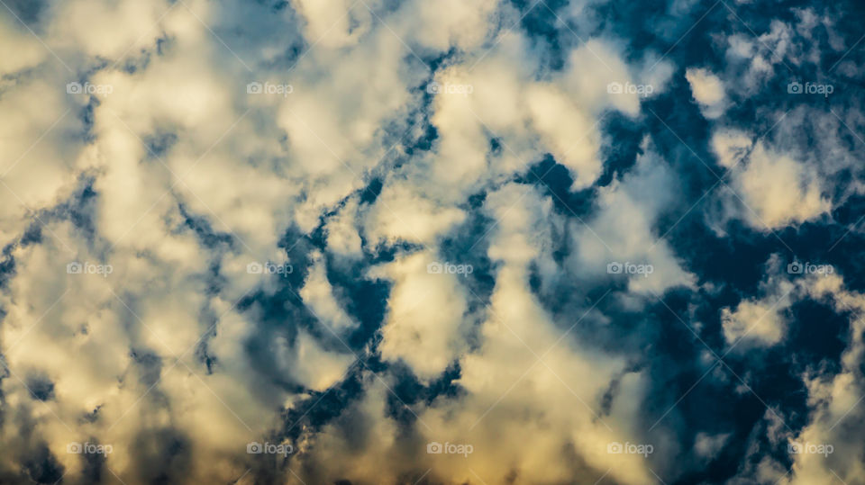 Large clouds float across the sunset sky like sails.