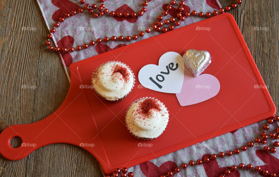 Red velvet cupcakes with Valentine's day sentiments on wood background