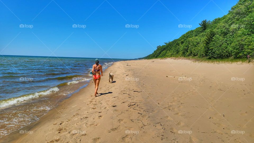 walking the dog on the beach in a bikini