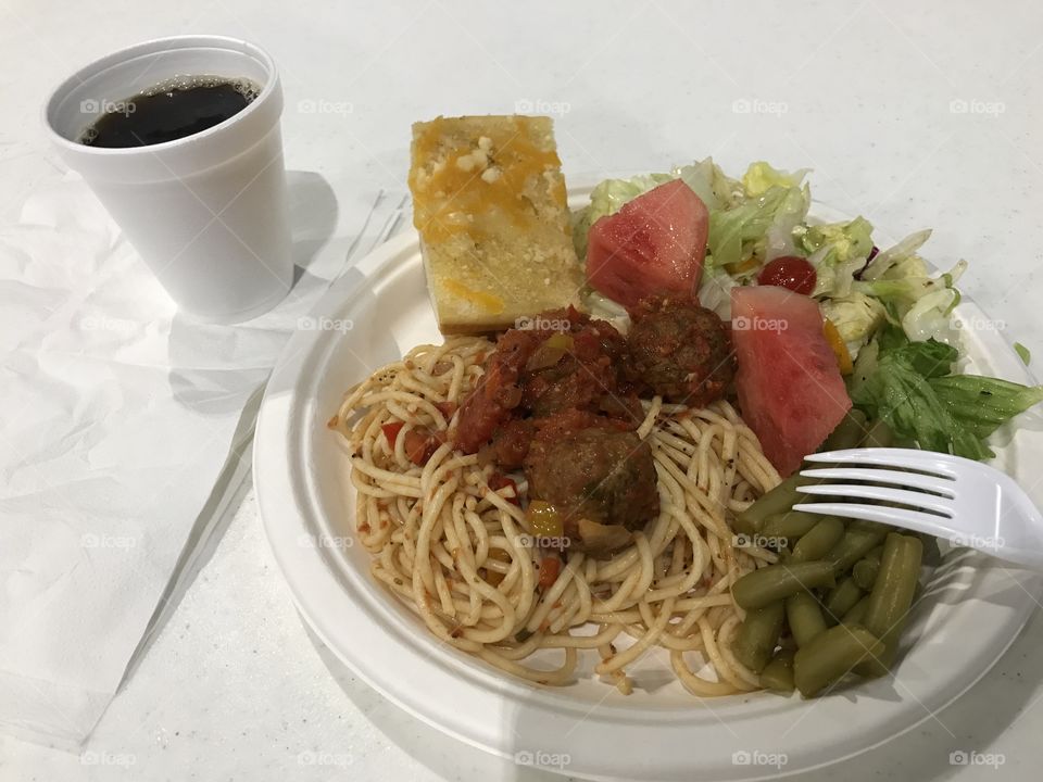 A simple black coffee with spaghetti dinner. There is nothing like drinking a healthy beverage like coffee while consuming spaghetti and other edibles for pleasure. Coffee consumption itself does have its personal joy.