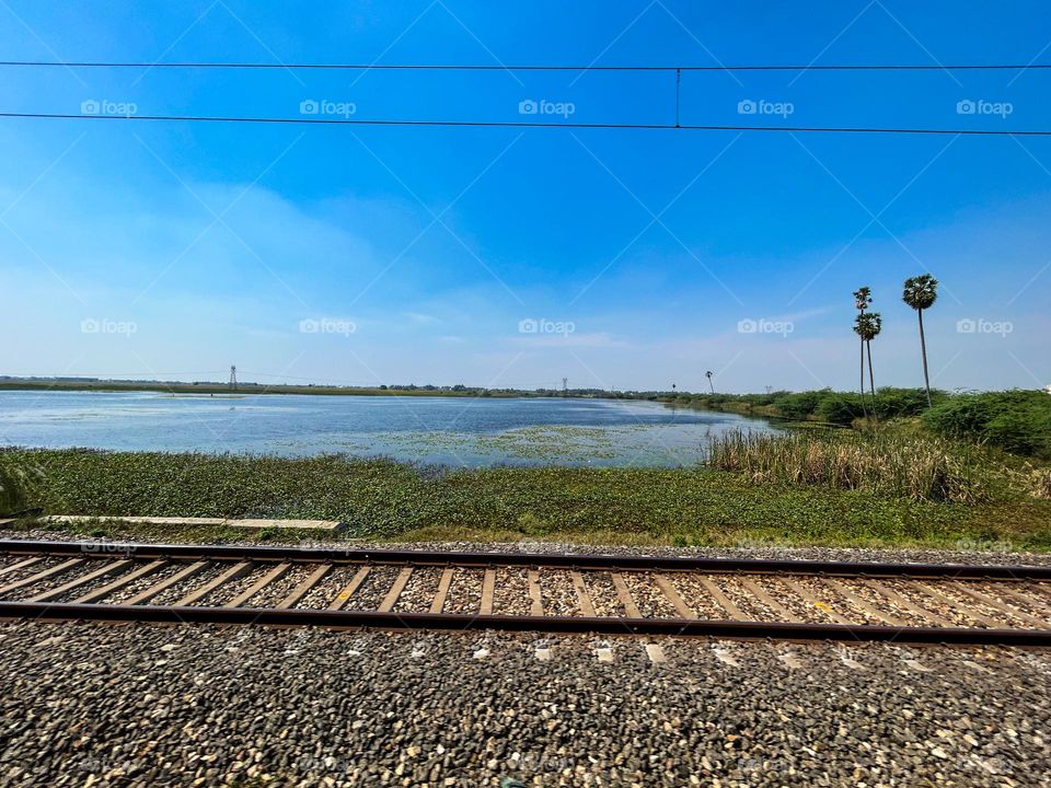 India - Railway track - Day light - water body - country side 