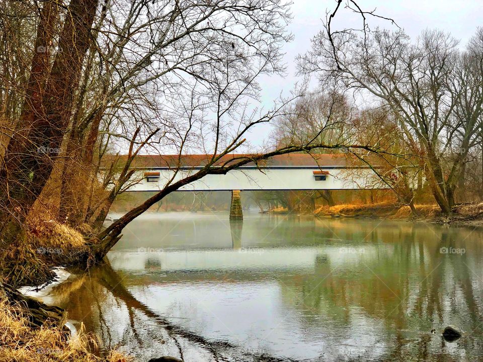 Winter foggy day on the river with the old Indiana covered bridge 