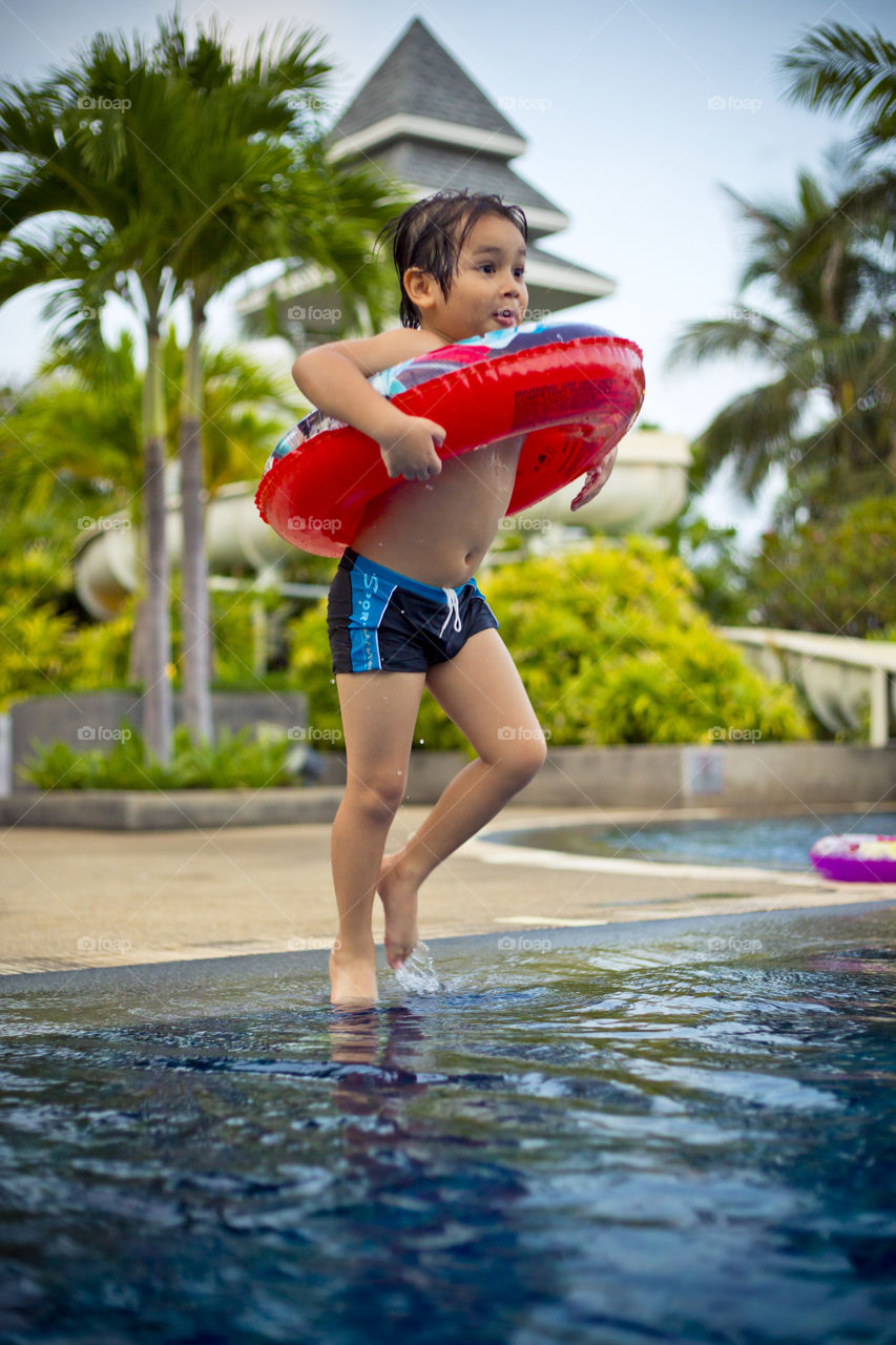 happy kid jumping in the pool, family activity summer time