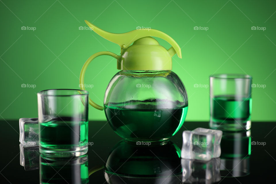 green tea and kettle on green background