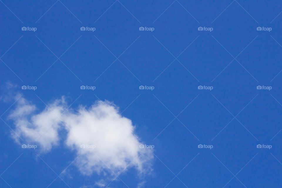 One wispy cloud against a vivid blue sky