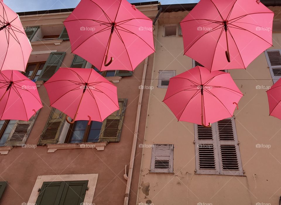 Decorative and useful pink umbrellas before old houses with shutters - Provence 