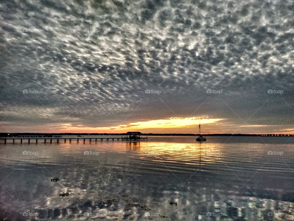 Radioactive Sunset. Was watching the sunset at my local county dock, the sky was checkered and my phone perfectly captured the reflection.