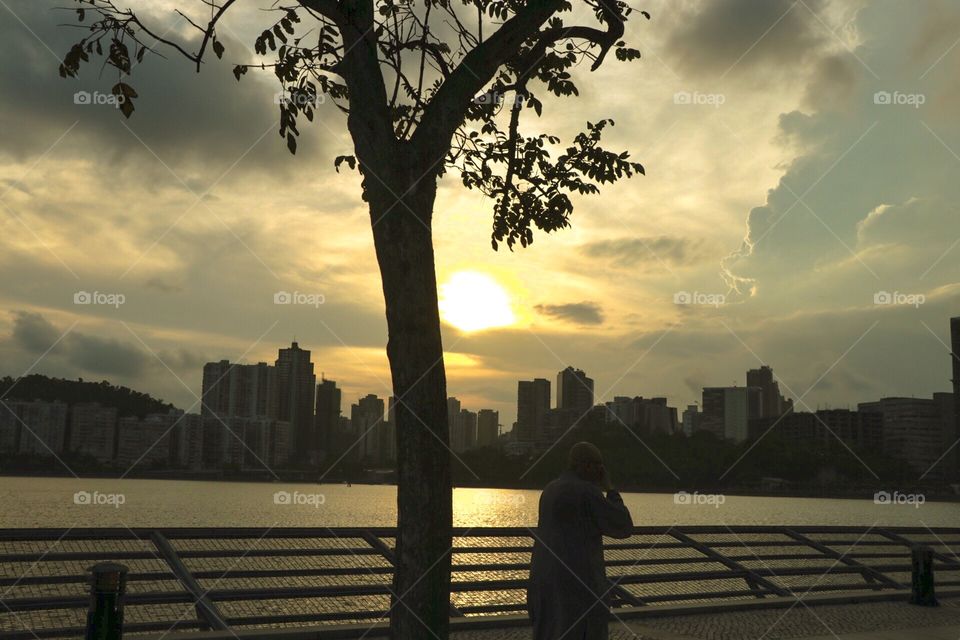 A monk enjoying the sunset at the reservoir park