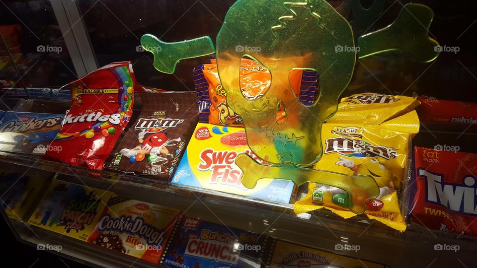 Poison skull and crossbones on a candy counter glass window.