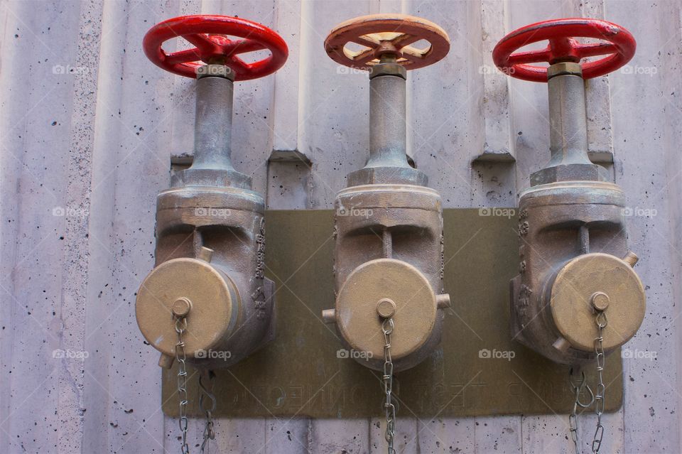 Three sprinkler couplings on the exterior of a building in Manhattan, New York City which connect and enable fire engines to pump water to the building.