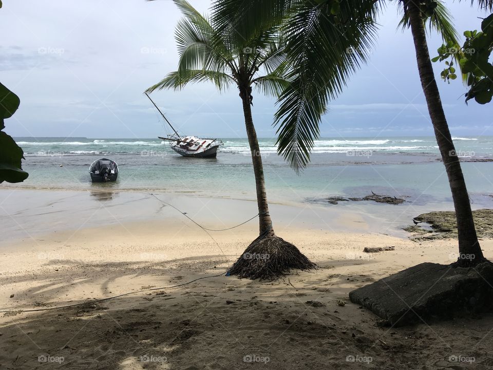 Boat leaning on tropical beach