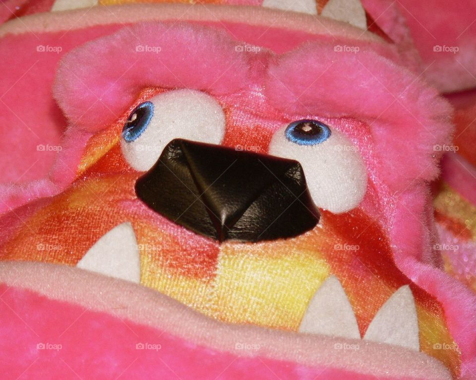 Deep thoughts. A closeup of plush pink monster prize waiting to be won on the midway 