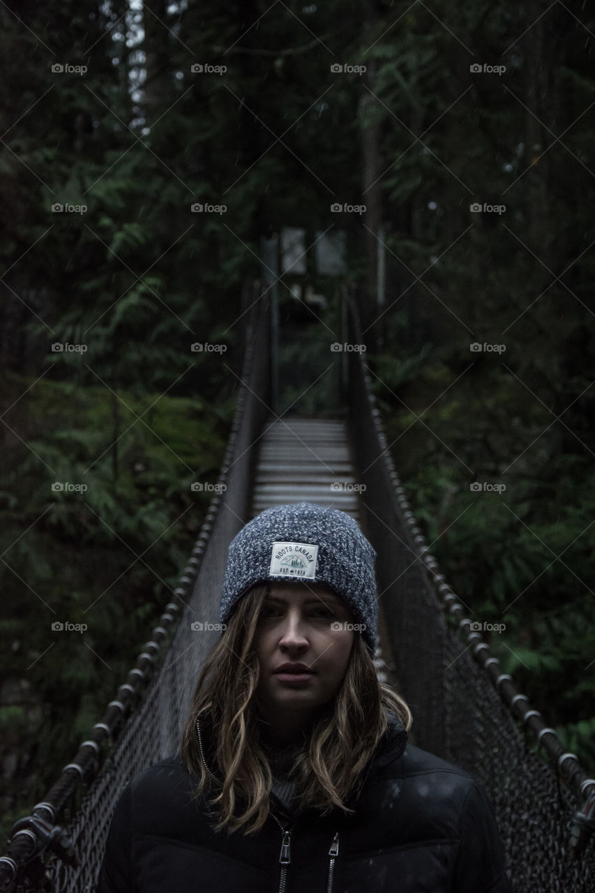 Young woman standing on suspension bridge