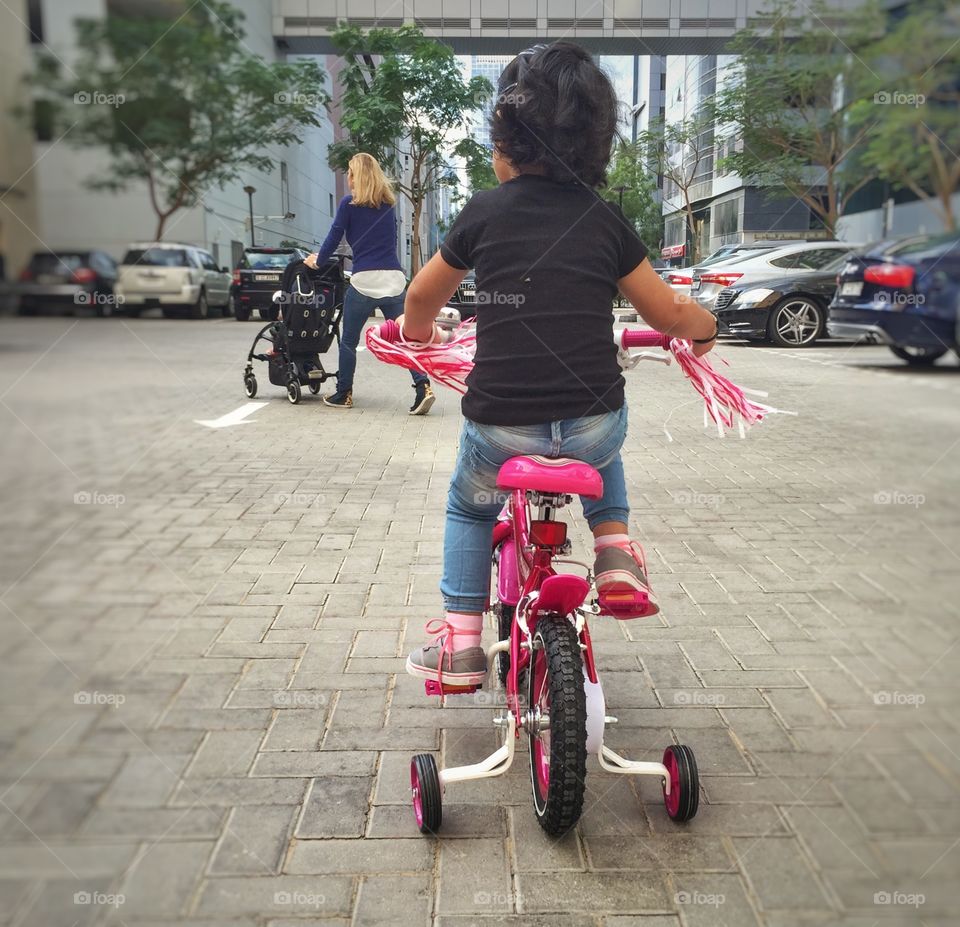 Toddler learning to ride a bicycle 
