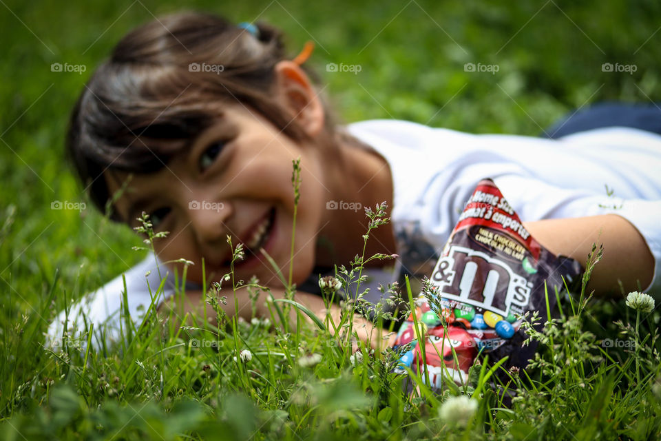Little cute girl with pack of M&Ms chocolates