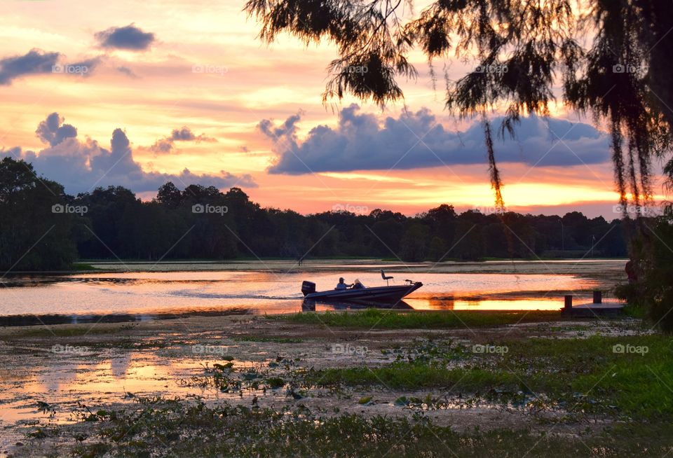 Man pulls up to dock as a beautiful sunset unfolds.