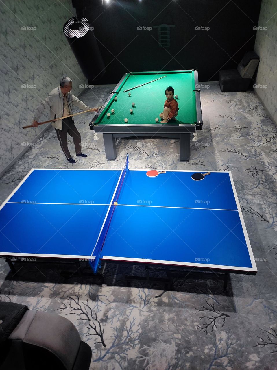 Grandfather and grandson enjoying quality time playing  billiards