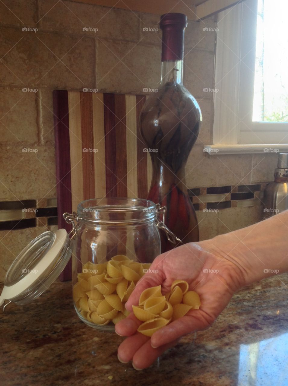 Holding in hand some pasta.