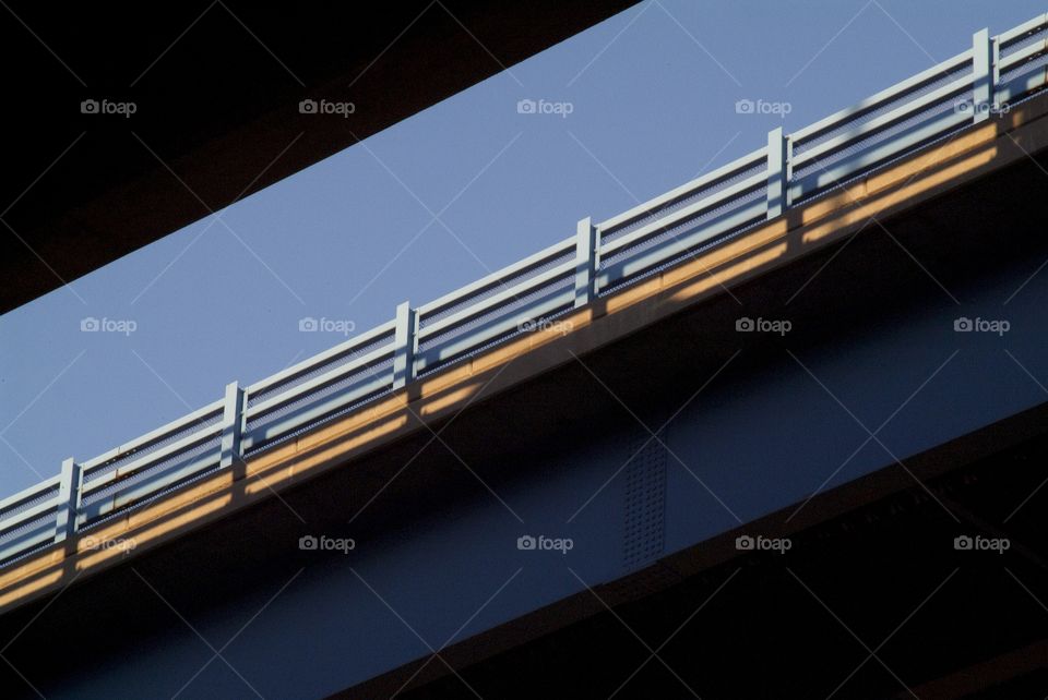 An elevated highway shot at a low angle reveal the days traffic above.