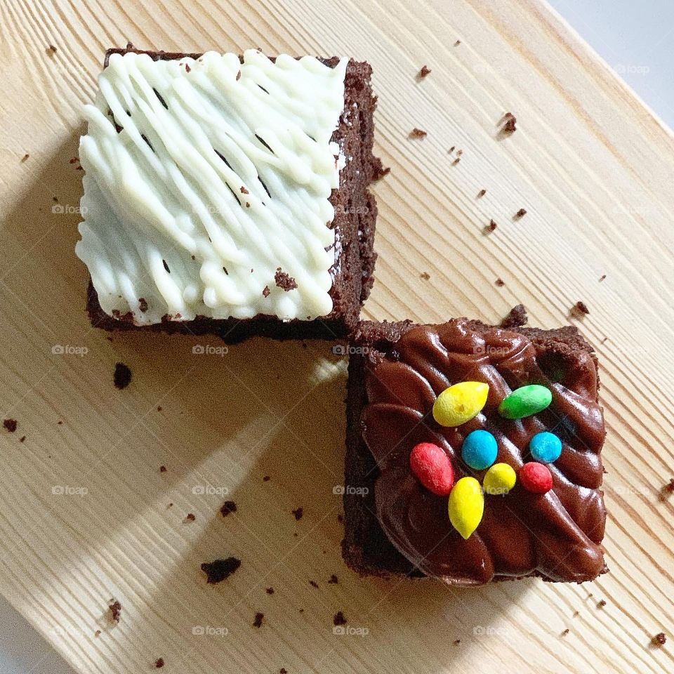 Home baked brownies in white chocolate drizzle and M&Ms sprinkles 