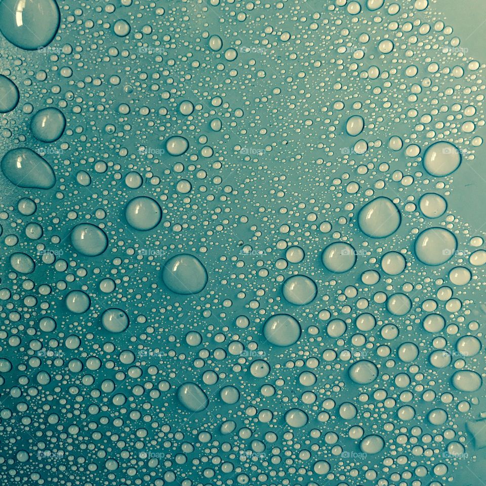 Water drops on smooth turquoise surface