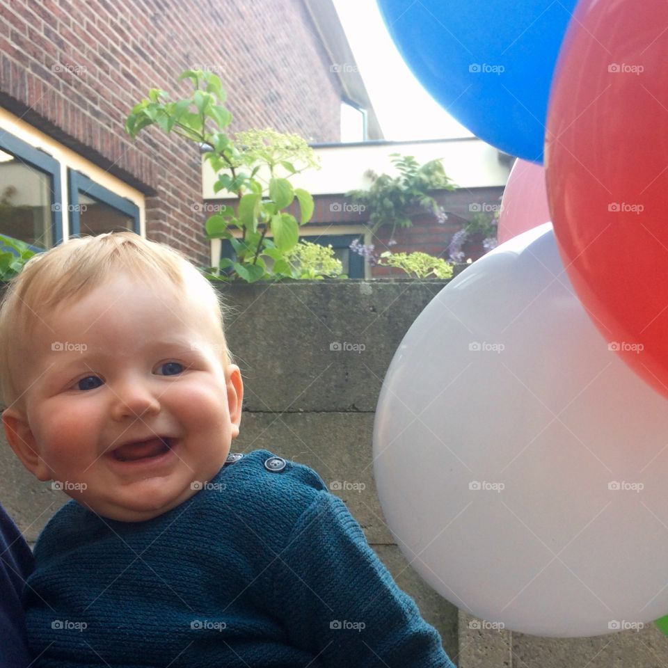 Smiling baby looking at balloons