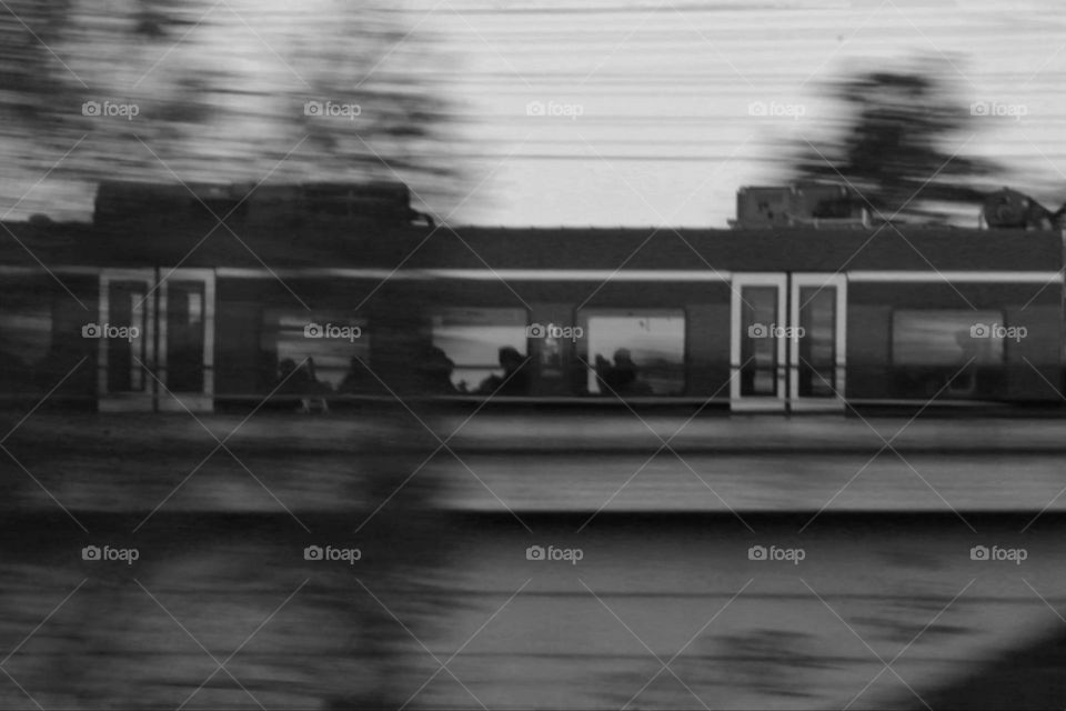 Black and white photo of people sitting in a moving train