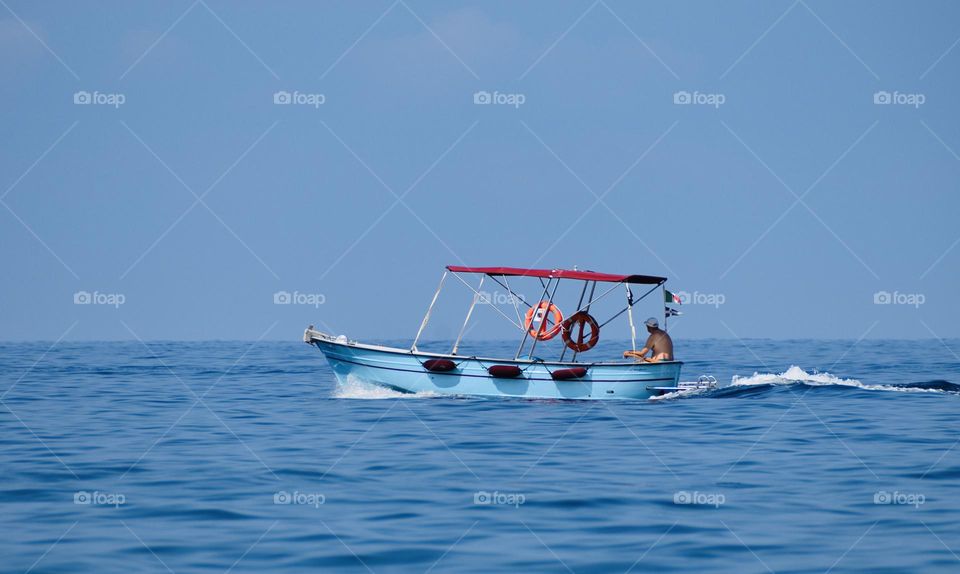 Blue boat sailing on a calm sea