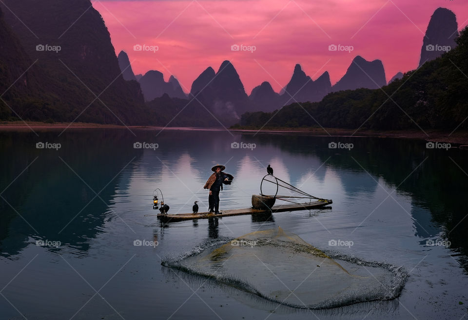 Cormorant fisherman throwing his net into the Li river