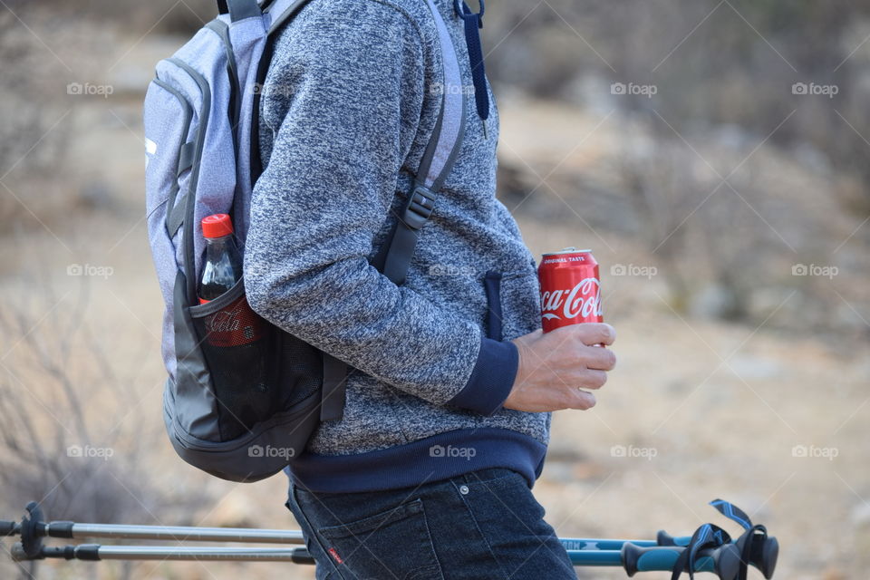 Taking a break with coke during a hike in the mountains 