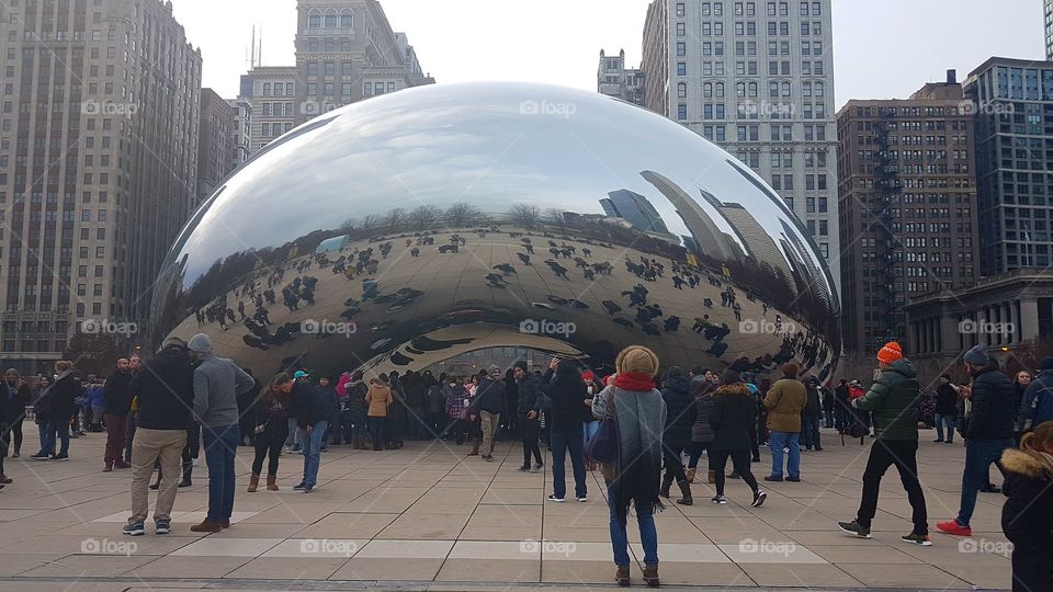 Chicago Cloud Gate bean sculpture day view with tourists.