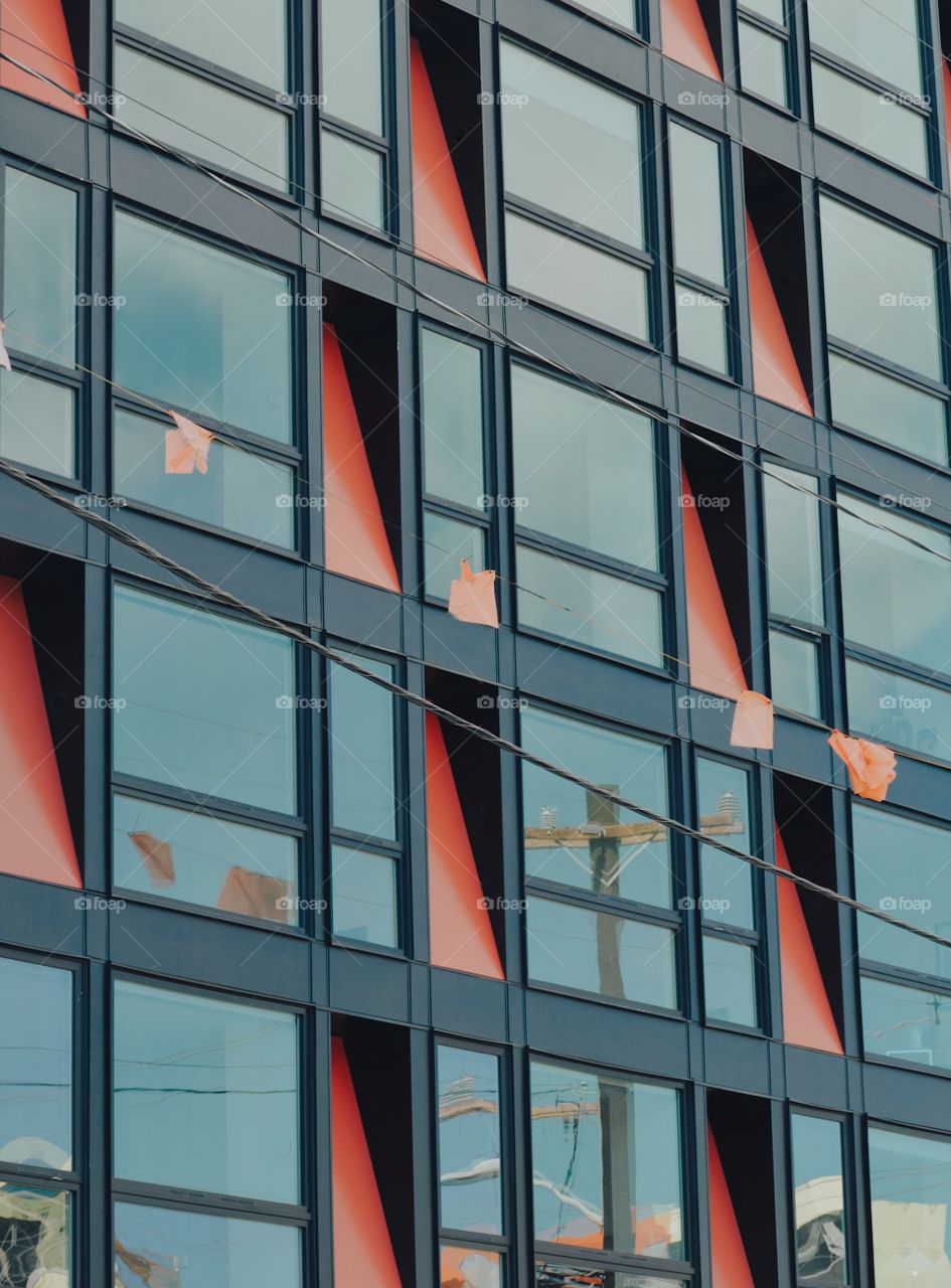 building side, orange and grey. beautiful mirror windows and contrasting modern color 
