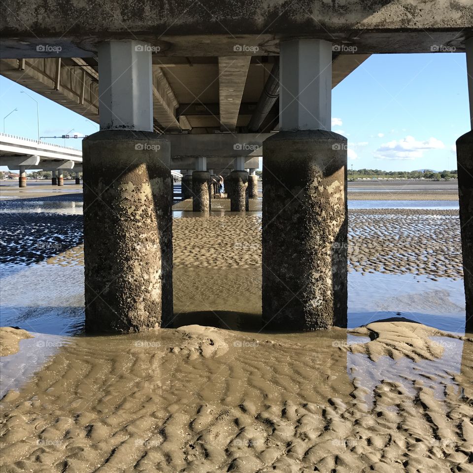 Under bridge, sandy, low tide, piers,