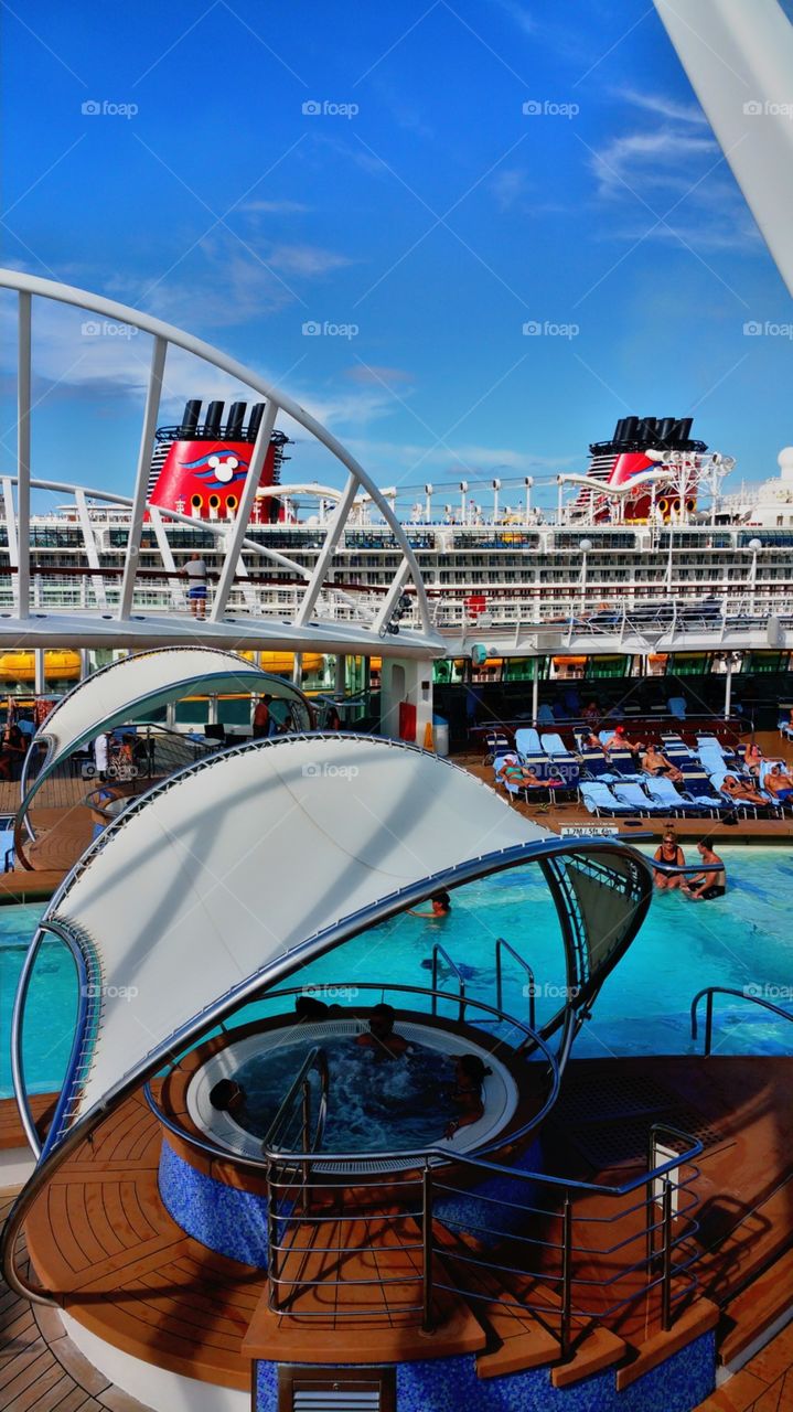 I love this picture cause you can see the tops of Disney Cruise ship with the water slide and red colors From Royal Caribbean Enchantment of the seas