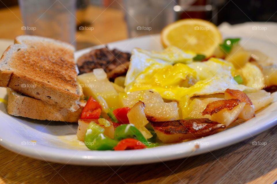Tasty and delicious country breakfast with skillet potatoes,toast,eggs and sausage.