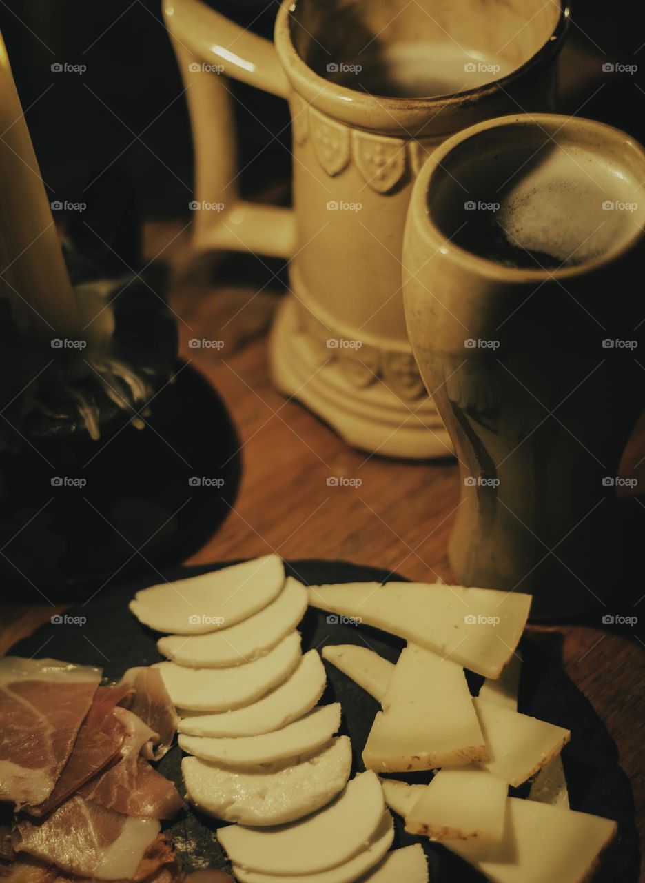 Meats and cheeses served with mead in old fashioned tankards