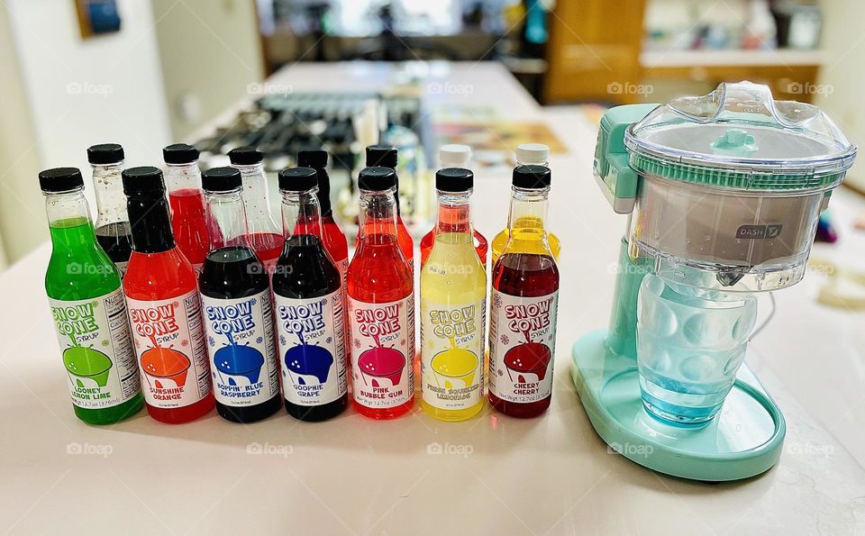 Snow cone machine, using a snow cone machine at home, homemade snow cones, rainbow of colors in syrup 