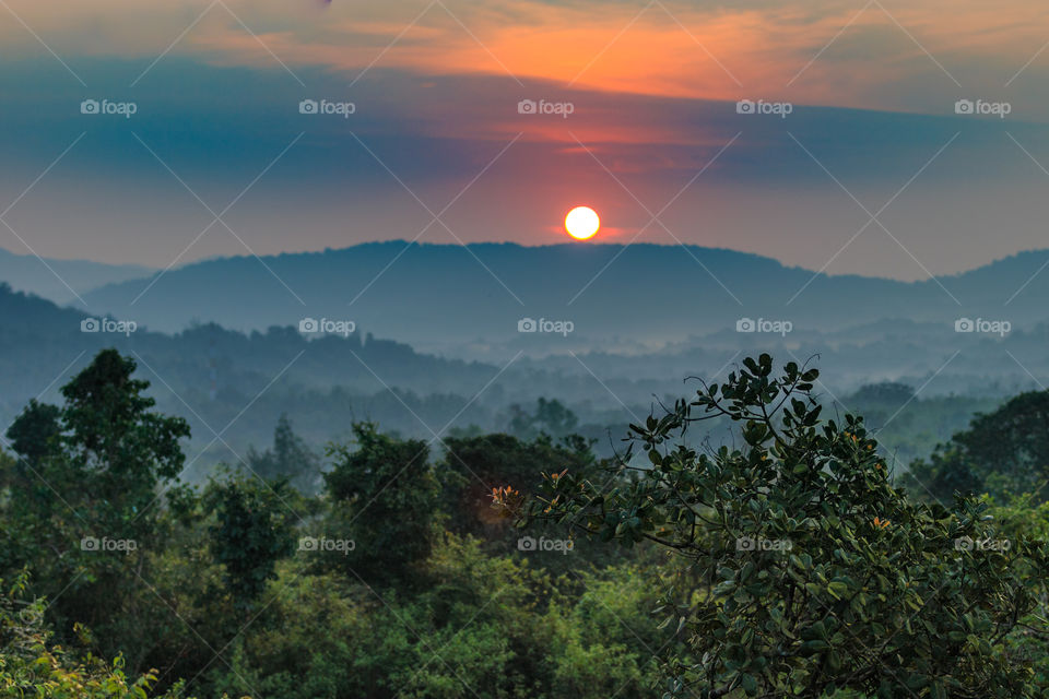 sunrise in a foggy morning over the mountains in a valley