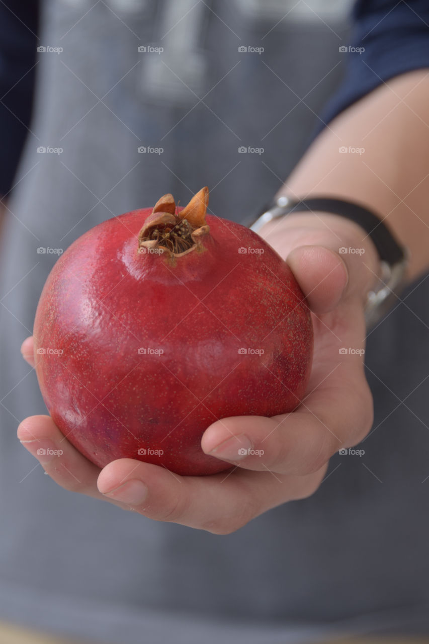 Exotic fruit, boys hand holding a pomegranate