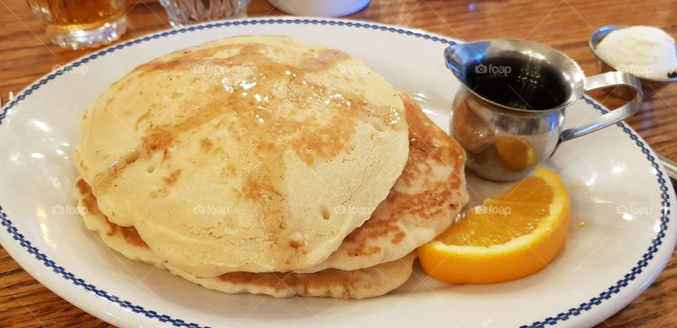 Stack of pancakes with syrup for breakfast on holiday in the USA