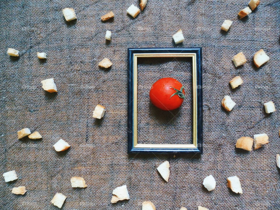 red tomato in a frame on a background of white crackers