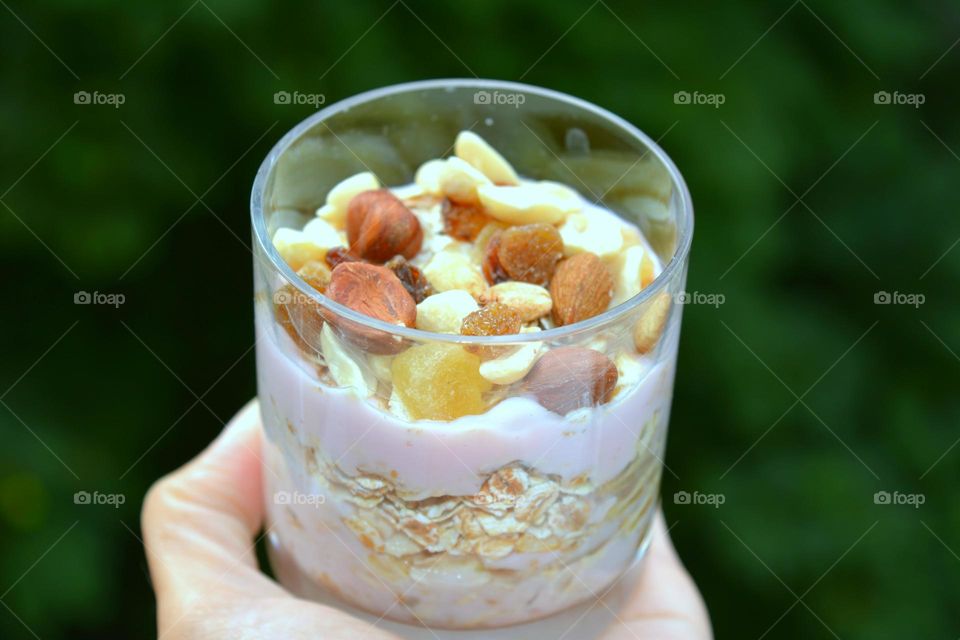 Person holding glass of granola