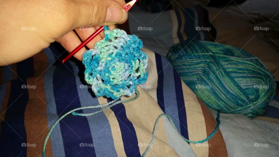 A woman who'm crocheting a canvas.