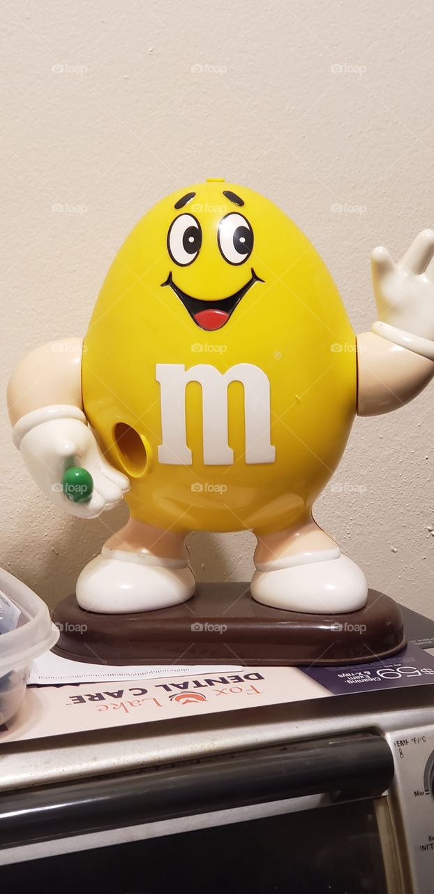 yellow M&M candy dispenser that is one of my prized possessions