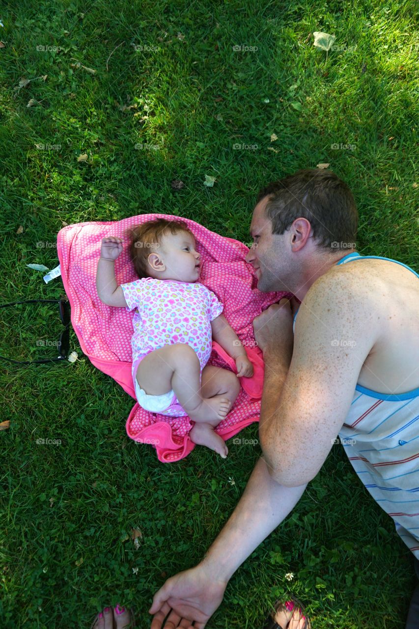 Elevated view of father with baby lying on grass