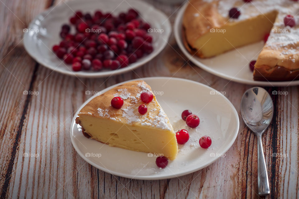 Cheesecake with cranberries and sugar on wooden background 