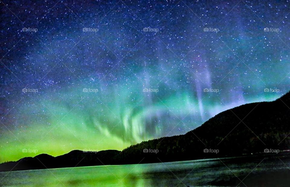 Multicoloured green, blue vibrant aurora. Borealis Polaris. Northern lights in night sky. 