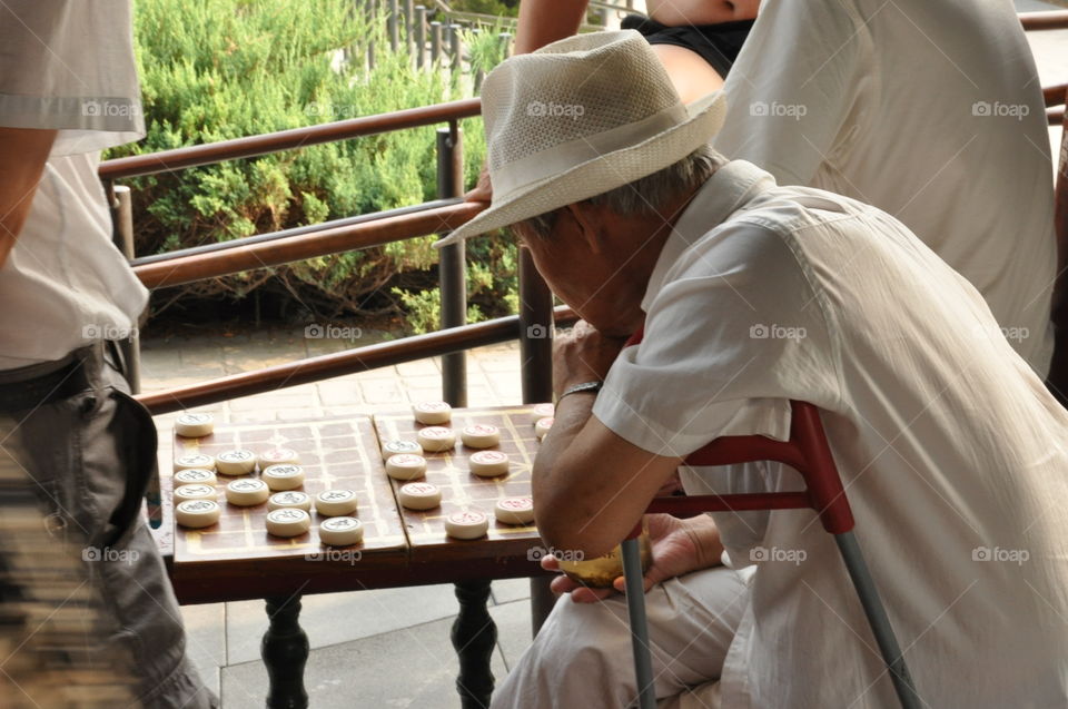 Old men playing Chinese chess in a park