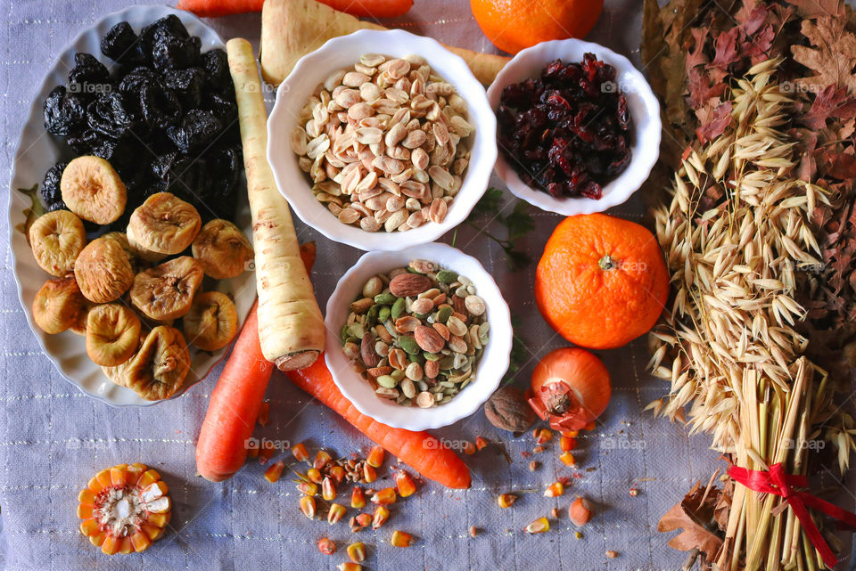 Healthy food on the table-dry fruit, nuts, corn, orange, carrot, wheat